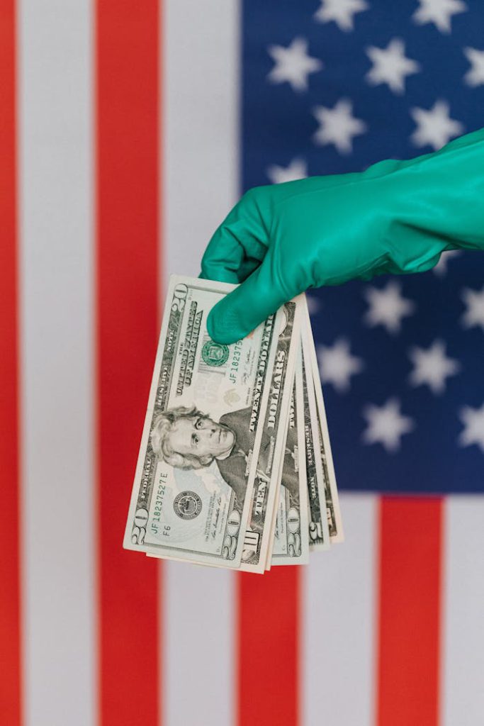 Mastering the First Impression: Your intriguing post title goes here Unrecognizable person wearing green latex glove showing heap of USA banknotes on blurred background of national flag of United States